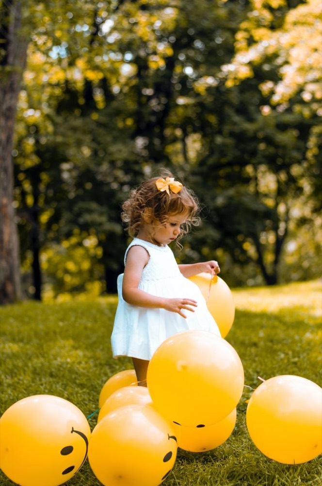 Petite fille jouant dehors avec des ballons, un temps de découverte en plein air